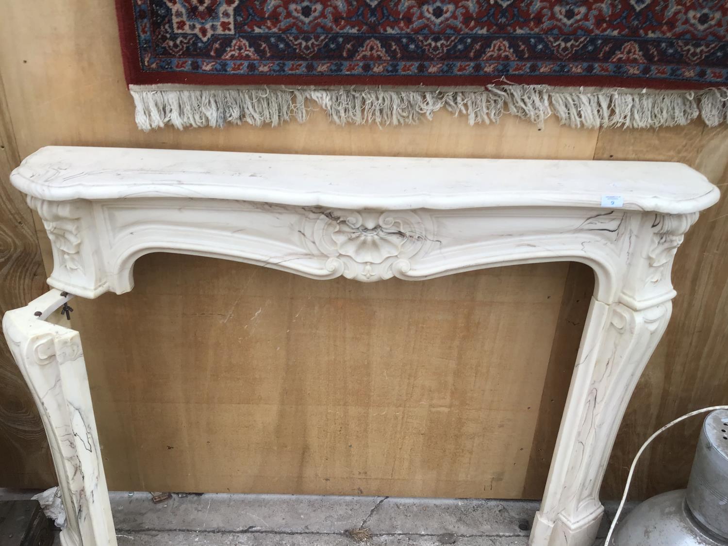 A DECORATIVE MARBLE EFFECT FIRE PLACE SURROUND