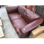 A BROWN LEATHER TWO SEATER SOFA