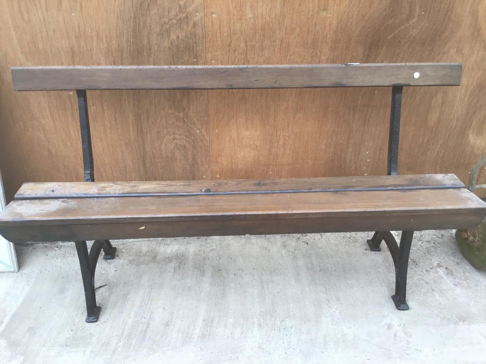 A WOODEN BENCH WITH CAST IRON BENCH ENDS DETAILED WITH 'UNITY WOOD & IRON CO PADIHAM' 157CM LONG