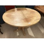 A LIGHT OAK CIRCULAR DINING TABLE