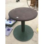 A ROUND WOODEN PUB STYLE TABLE ON A GREEN CAST IRON BASE