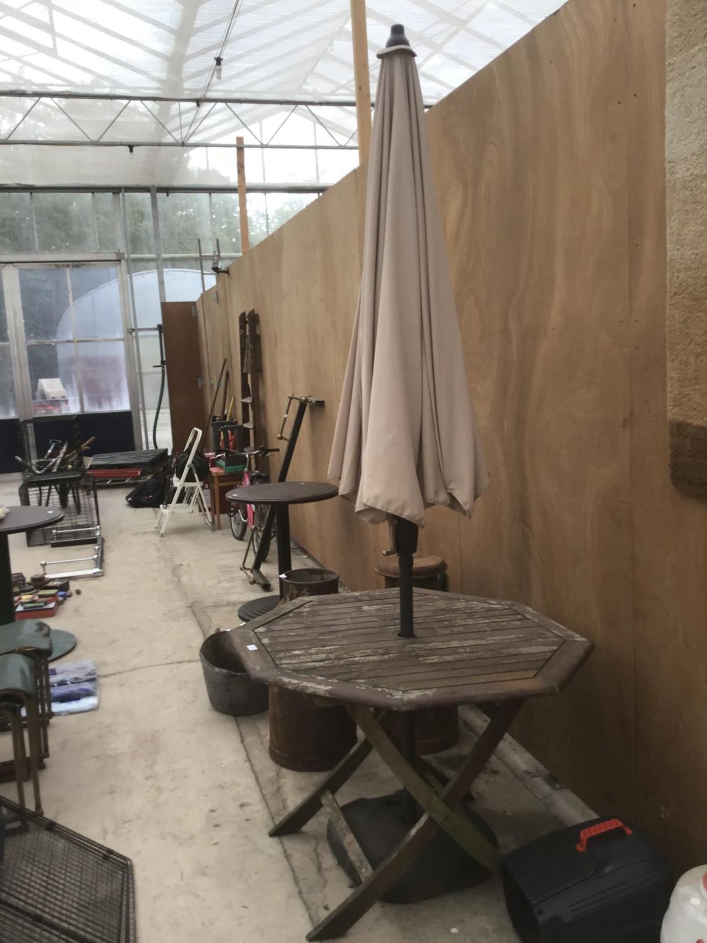 AN OCTAGONAL WOODEN GARDEN TABLE WITH PARASOL