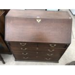 AN OAK BUREAU WITH FALL FRONT AND LOWER DRAWERS