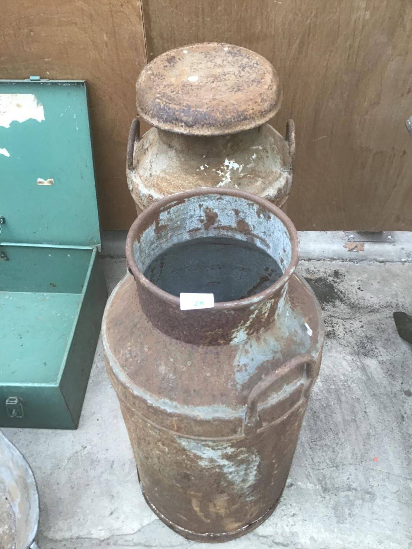 A PAIR OF VINTAGE MILK CHURNS (ONE WITH CORROSION TO THE BASE)