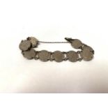 A SILVER BRACELET WITH NINE SILVER THREEPENNYS