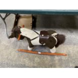 A CHILDS ROCKING HORSE ON WOODEN BASE