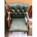 A GREEN LEATHER BUTTON BACK ARMCHAIR