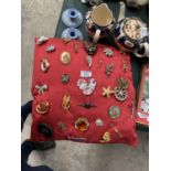 A SILK CUSHION WITH ASSORTED COSTUME JEWELLERY BROOCHES