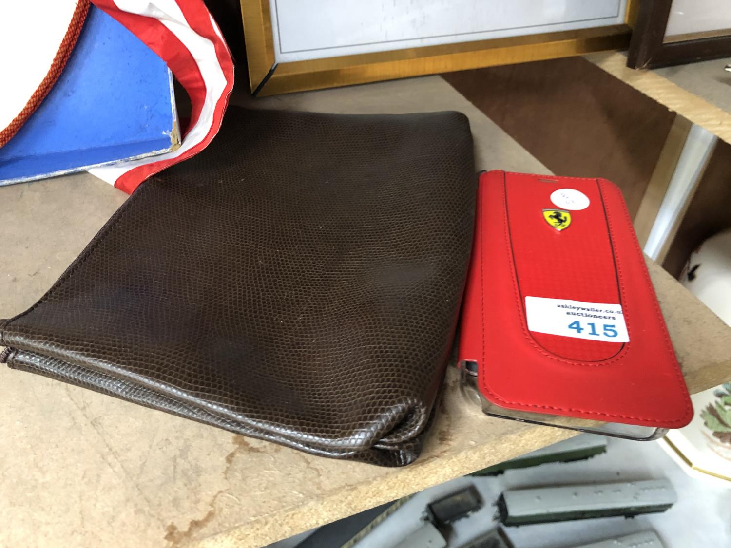 A BROWN LEATHER EFFECT WALLET AND FERRARI BRANDED PHONE CASE