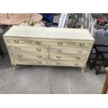 A FRENCH STYLE CREAM CHEST OF NINE DRAWERS AND A MATCHING DOUBLE HEADBOARD
