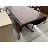 A DROP LEAF MAHOGANY DINING TABLE ON CENTRE PEDESTAL SUPPORT