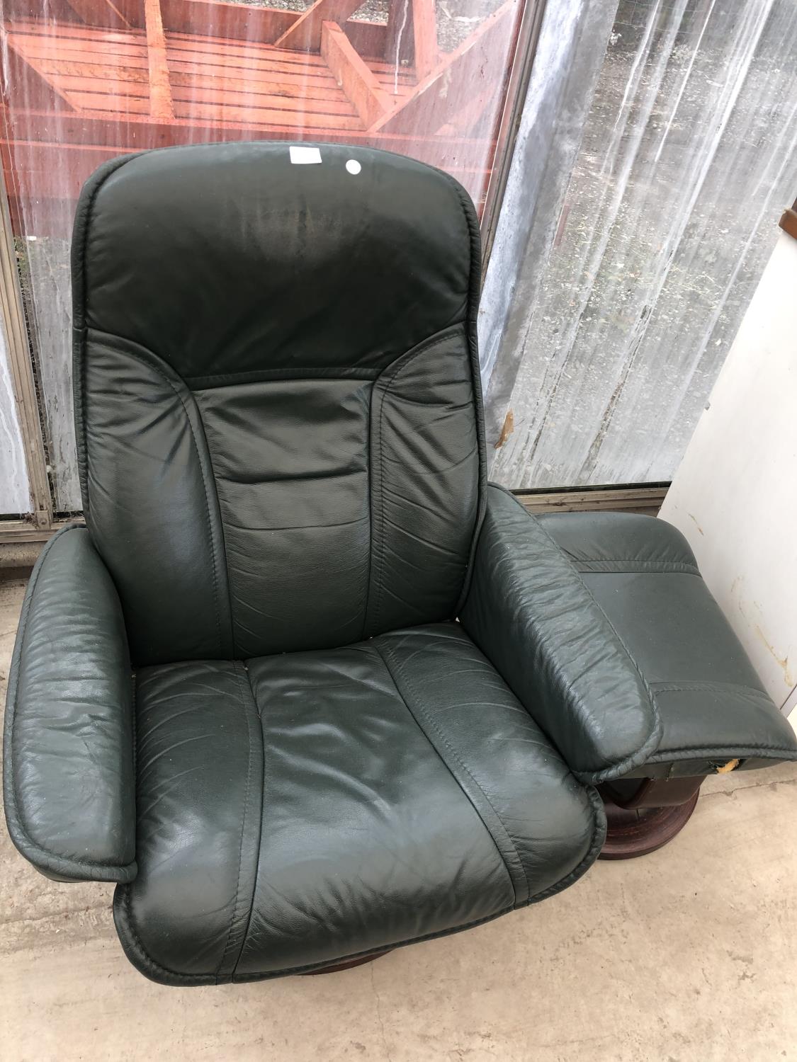 A GREEN STRESS-LESS ARMCHAIR AND FOOTSTOOL