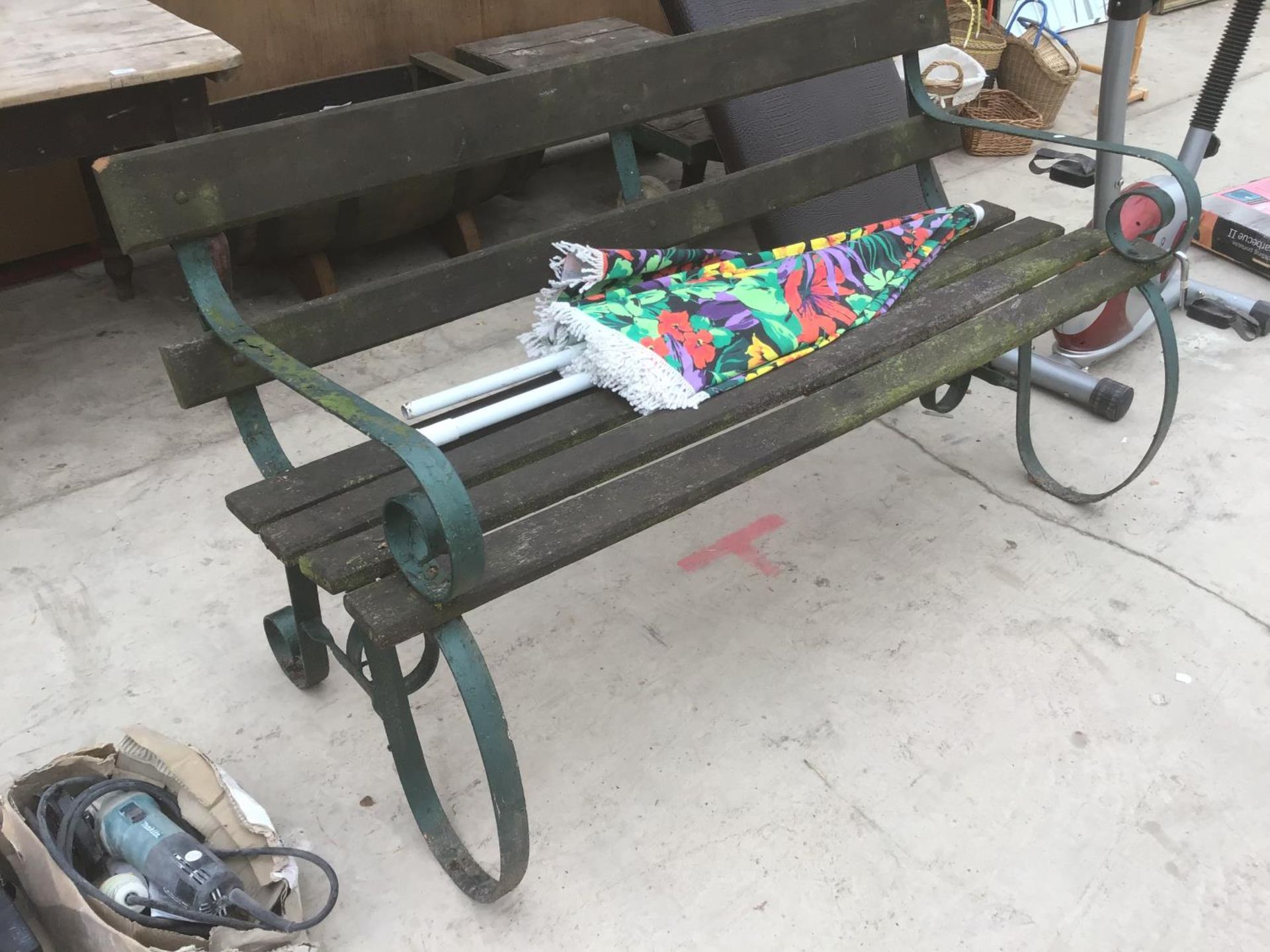 A WOODEN BENCH WITH CAST IRON ENDS AND A PARASOL