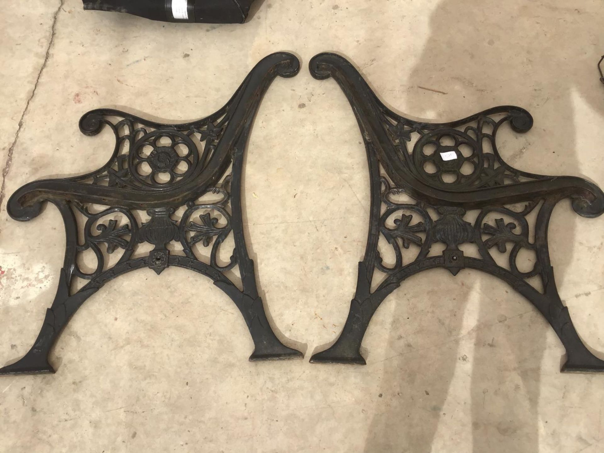 A PAIR OF ORNATE CAST IRON BENCH ENDS