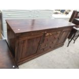AN INDONESIAN WOOD SIDEBOARD WITH TWO DOORS AND FOUR DRAWERS
