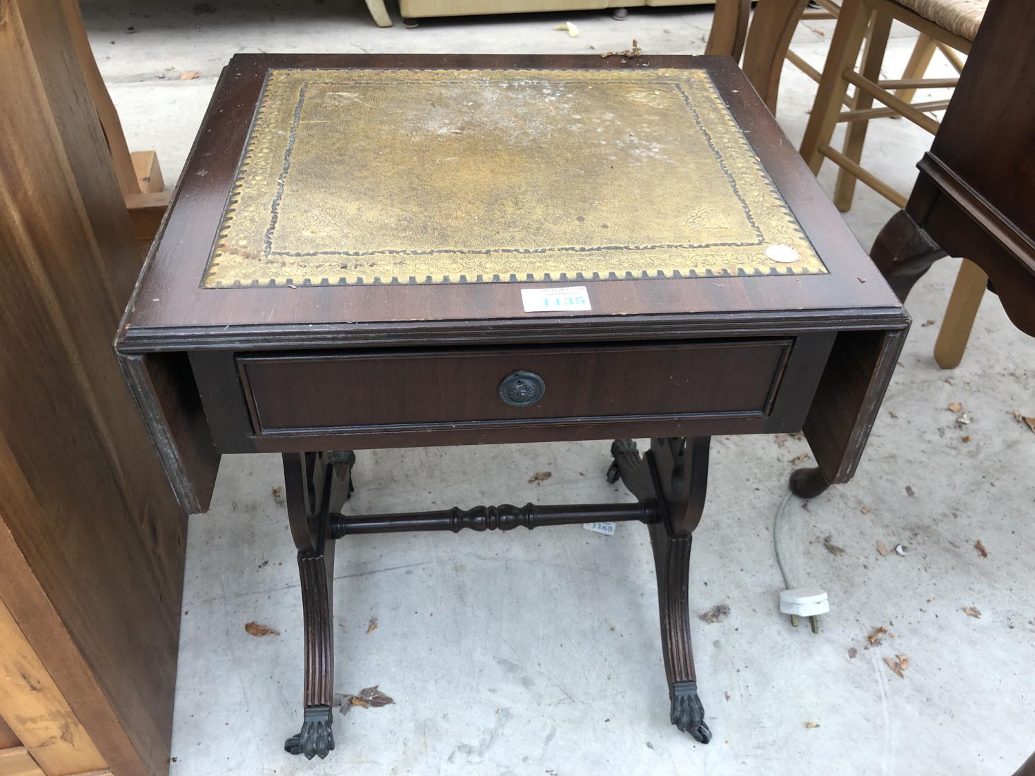 A LEATHER TOPPED SMALL SOFA SIDE TABLE WITH PAW FEET