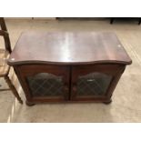 A MAHOGANY TV CABINET WITH TWO GLAZED DOORS