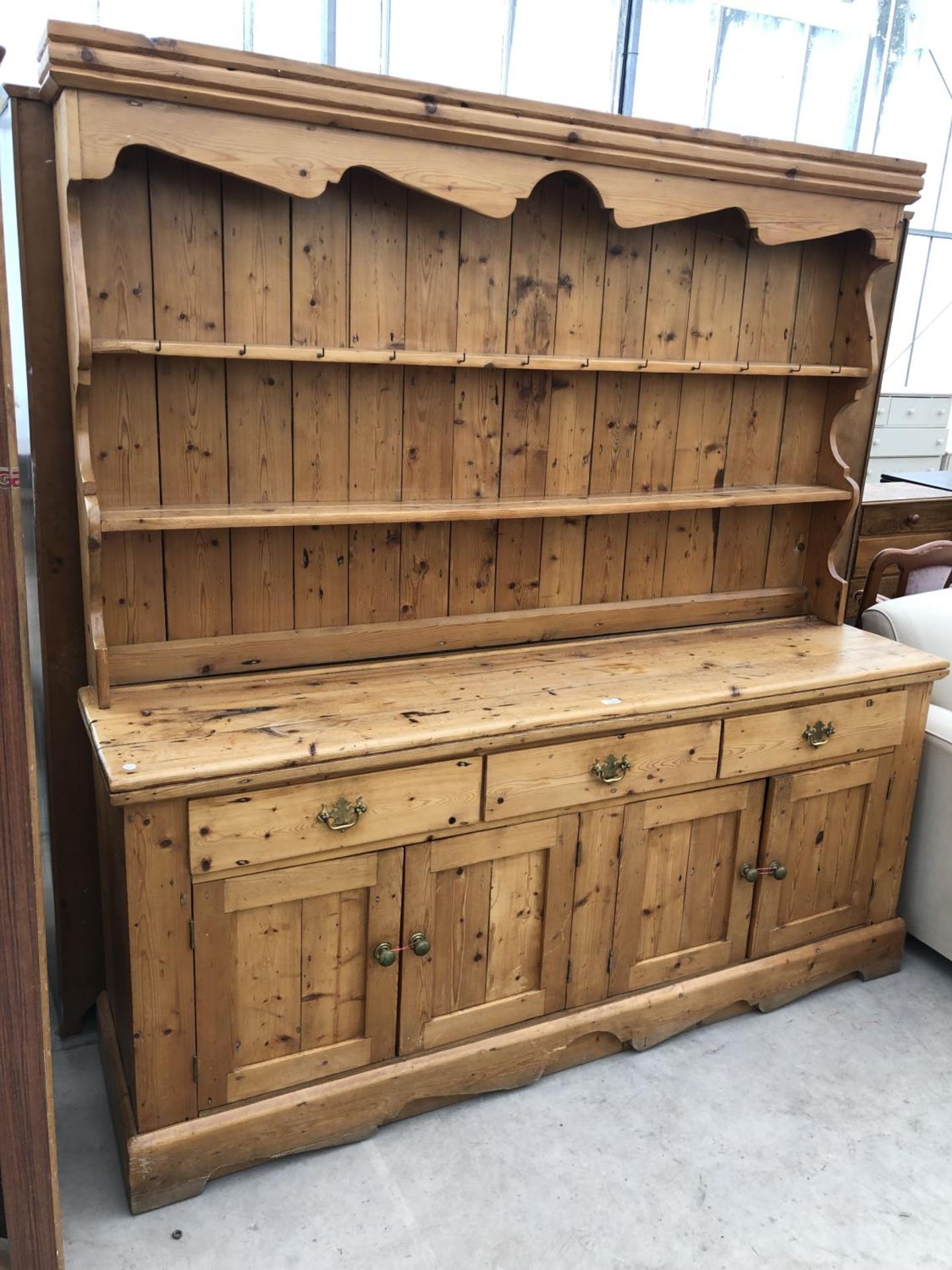 A LARGE PINE FARMHOUSE DRESSER WITH UPPER PLATE RACK AND LOWER DOORS AND DRAWERS