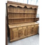 A LARGE PINE FARMHOUSE DRESSER WITH UPPER PLATE RACK AND LOWER DOORS AND DRAWERS