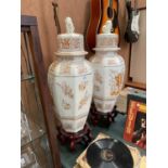A PAIR OF LARGE CERAMIC VASES ON WOODEN BASES