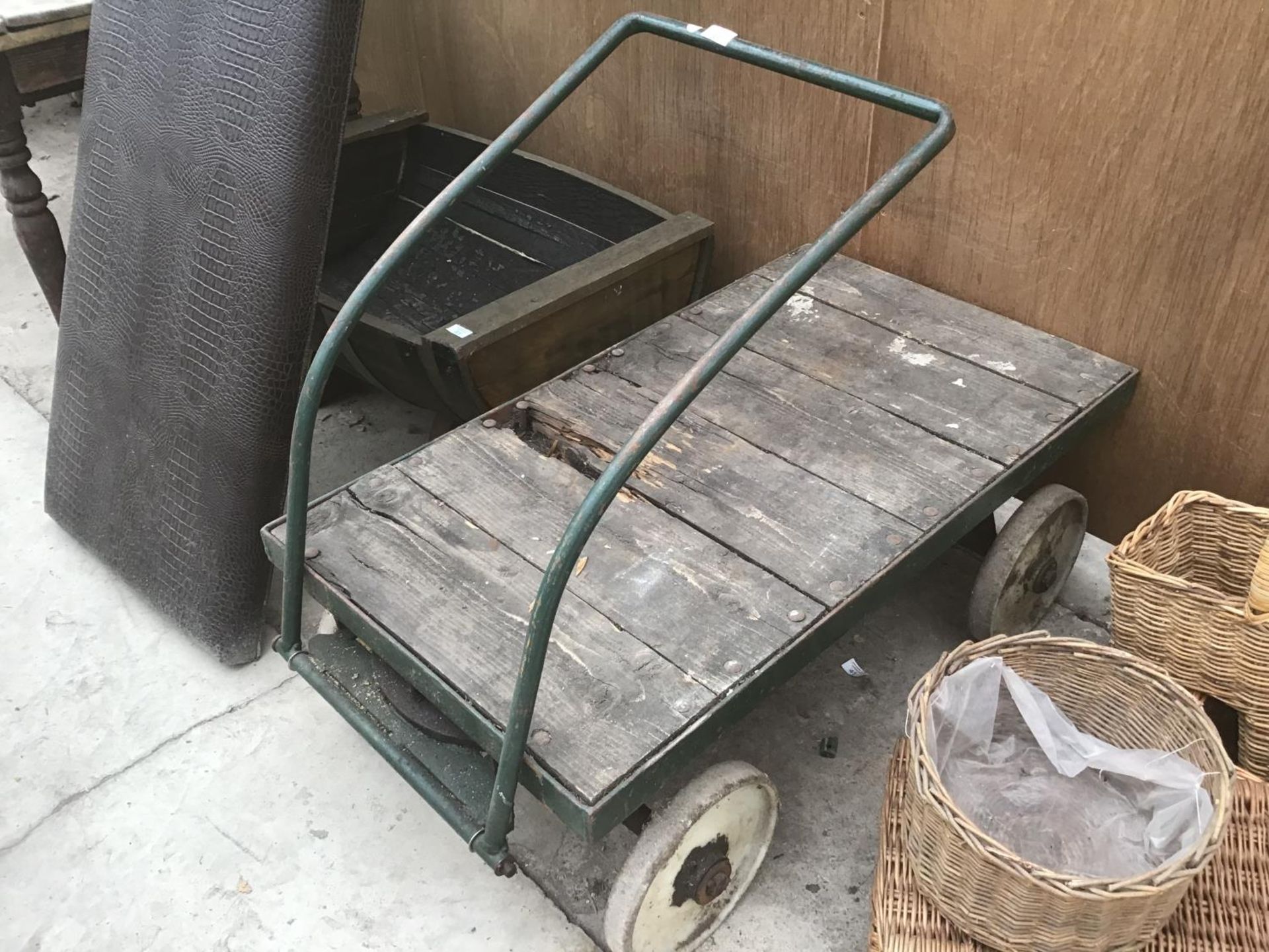 A VINTAGE FOUR WHEELED WOODEN TRUCK WITH METAL WHEELS