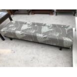 A LONG UPHOLSTERED FOOTSTOOL