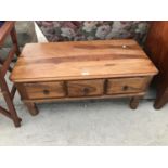 AN INDONESIAN WOOD COFFEE TABLE WITH THREE DRAWERS