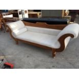 A PINE CHAISE LOUNGE WITH CREAM UPHOLSTERY