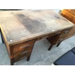 A VINTAGE OAK DESK WITH FIVE SHORT DRAWERS AND ONE LONG DRAWER