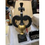 A BLACK AND GOLD LAMP BASE TOGETHER WITH TWO SHADES