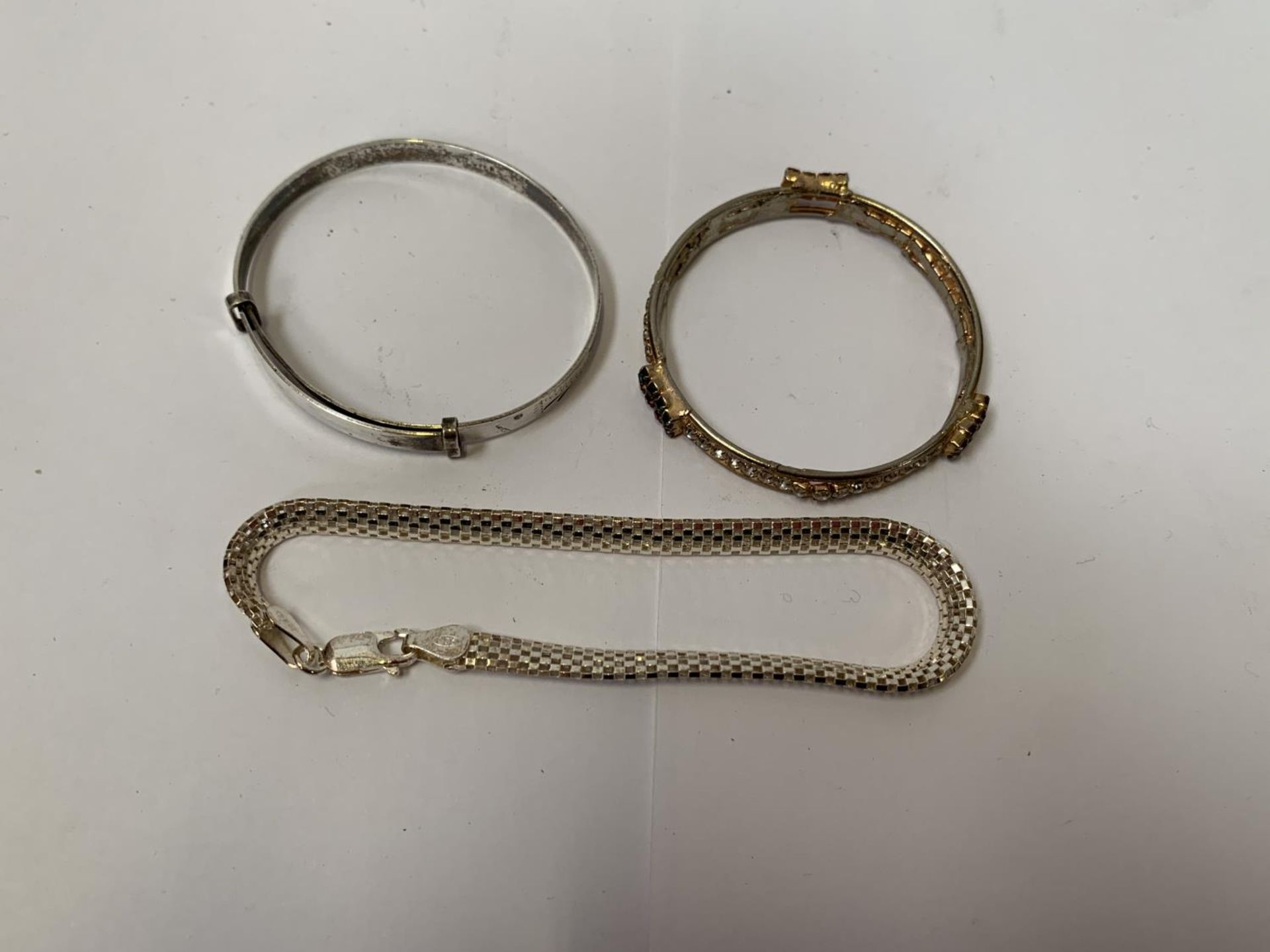 TWO BANGLES TOGETHER WITH A SILVER BRACELET