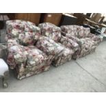 A FLORAL THRE SEATER SOFA WITH TWO MATCHING ARMCHAIRS AND A FOOTSTOOL