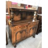 A CARVED OAK SIDEBOARD WITH TWO SHORT DRAWERS AND TWO DOORS