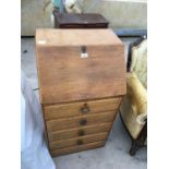 AN OAK FALL FRONT DESK WITH FOUR LOWER DRAWERS