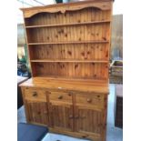 A MODERN PINE DRESSER WITH A THREE SHELVED PLATE RACK, THREE DRAWERS AND THREE DOORS