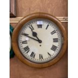 AN OAK CASED CIRCULAR WALL CLOCK