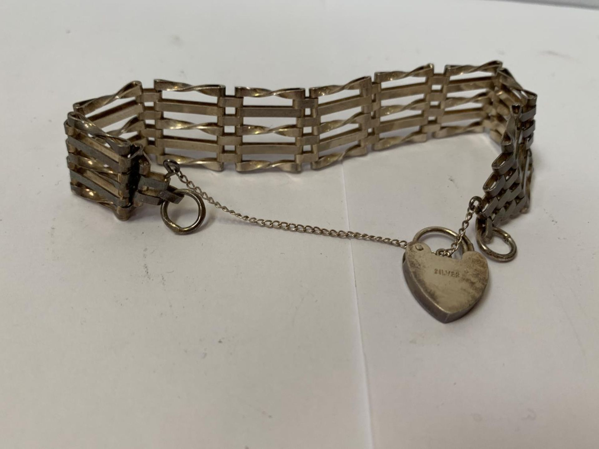 A SILVER BRACELET WITH HEART CHARM