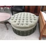 A GREEN BESPOKE MADE BUTTON TOP CIRCULAR OTTOMAN WITH CRYSTAL FRINGING. THIS IS MADE FROM