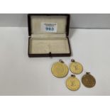 A COLLECTION OF FOUR LOUIS VUITTON MEDALLIONS