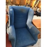A BLUE WING BACK ARMCHAIR