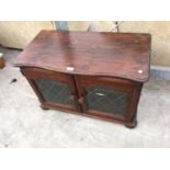 A PINE TV CABINET WITH TWO GLAZED DOORS