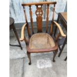 A MAHOGANY ARMCHAIR WITH RATTAN SEAT (REQUIRES ATTENTION)