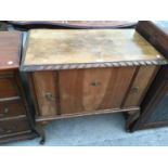 A MAHOGANY CHEST WITH TWO SMALL DOORS AND A DROP DOWN DOOR