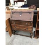 AN OAK FALL FRONT DESK WITH TWO LOWER DRAWERS