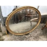 AN OVAL GILT FRAMED MIRROR