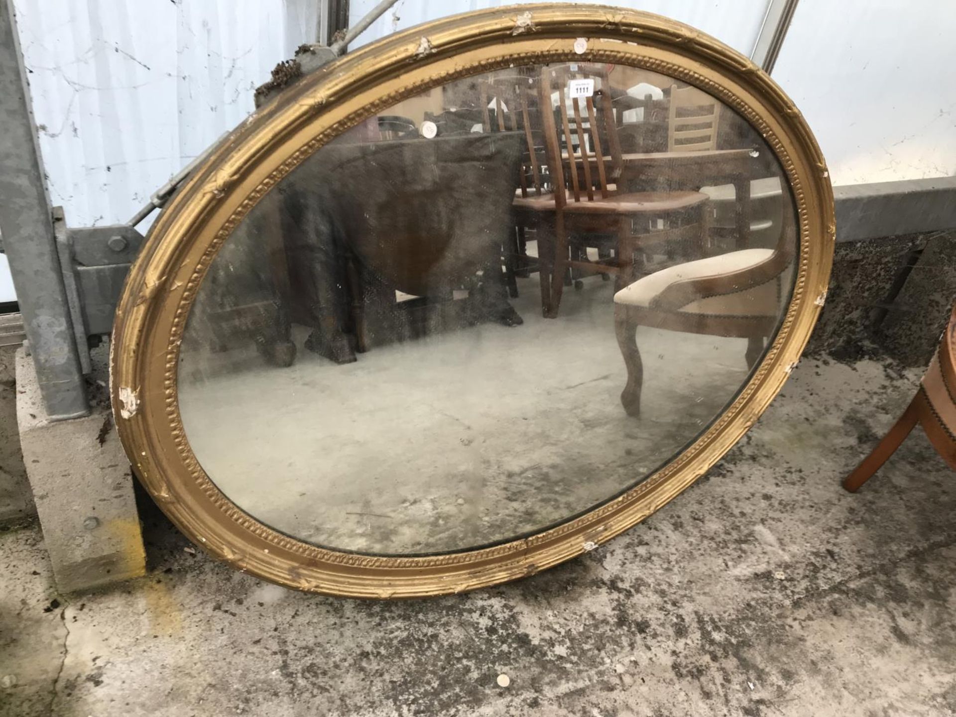 AN OVAL GILT FRAMED MIRROR