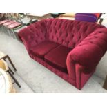 A DEEP RED CHESTERFIELD STYLE TWO SEATER SOFA