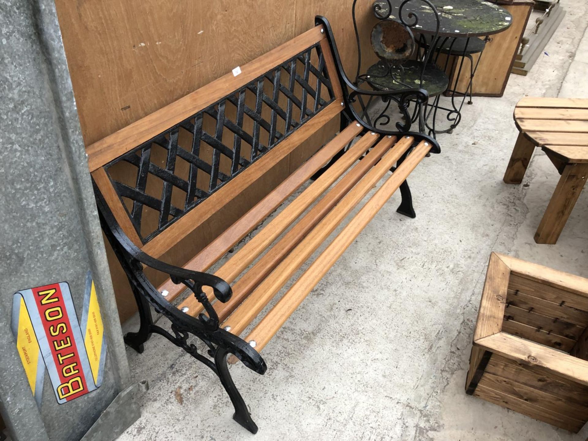 A WOODEN GARDEN BENCH WITH CAST SLATTED BACK AND ENDS