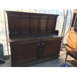 AN OAK SIDEBOARD WITH TWO DOORS, TWO DRAWERS AND PANELLED SPLASHBACK