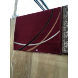 A MODERN DEEP RED RUG WITH CURVED STRIPE DESIGN